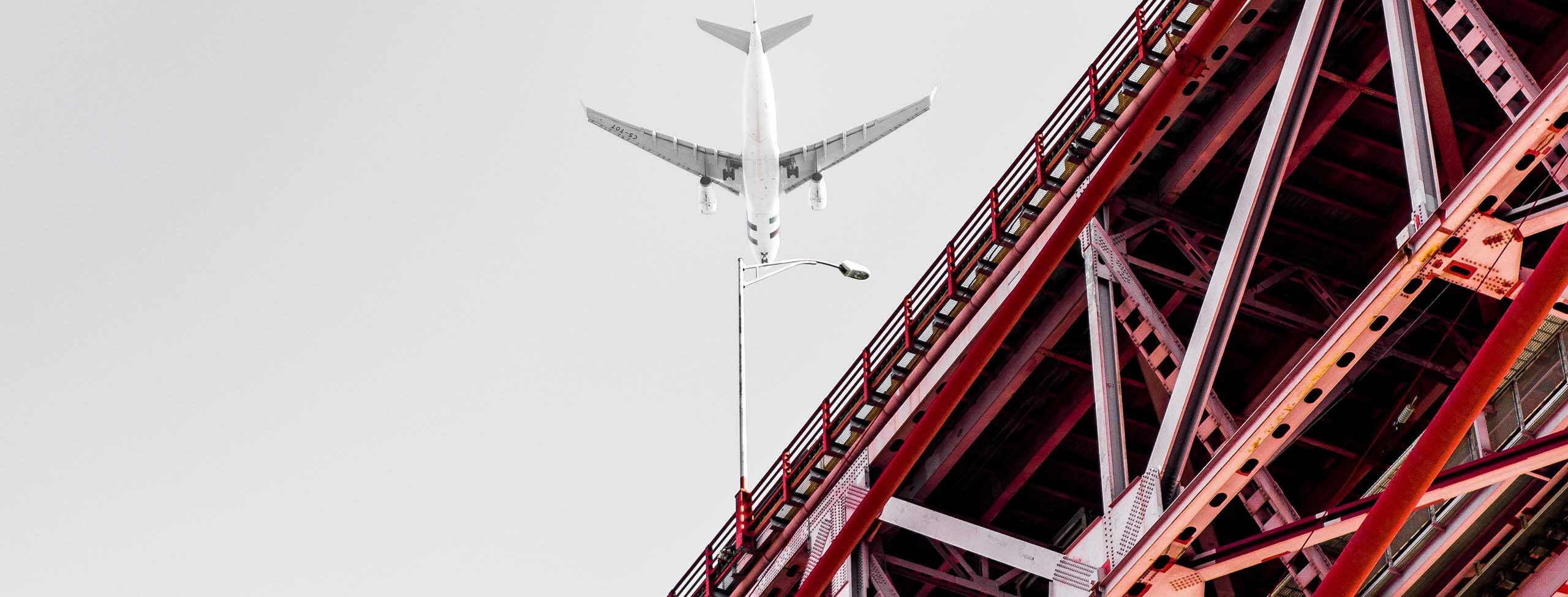 Airplane flying over bridge